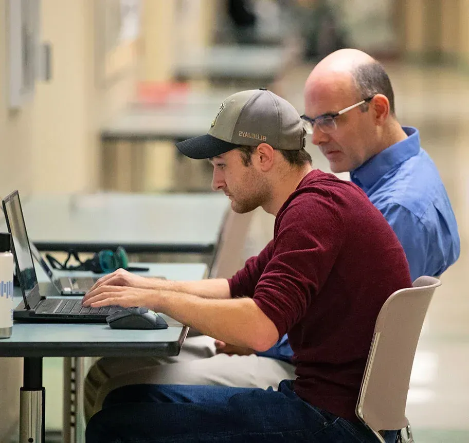 Physics faculty and student working tongether at laptop